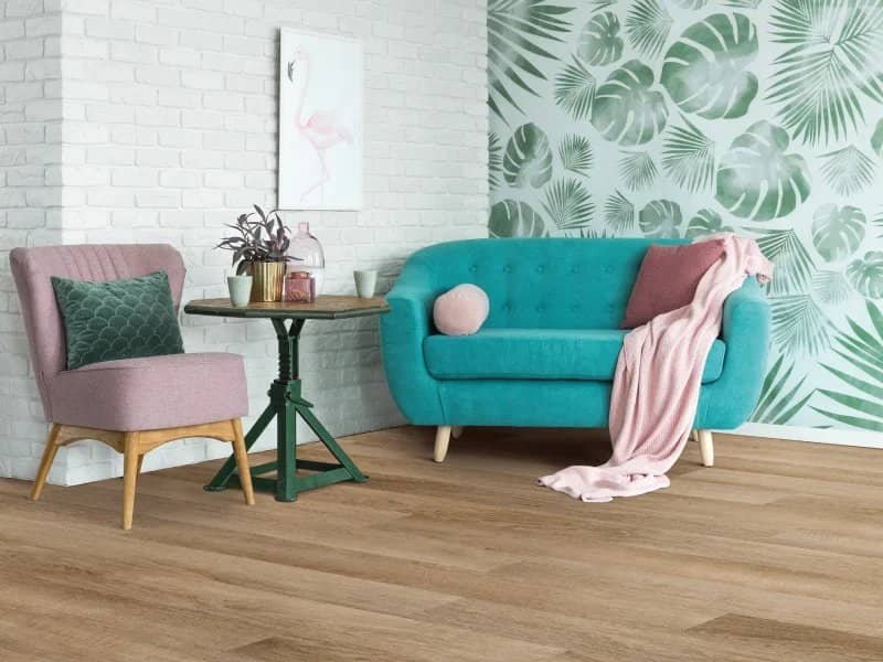 blue couch in living space with leaf wall paper